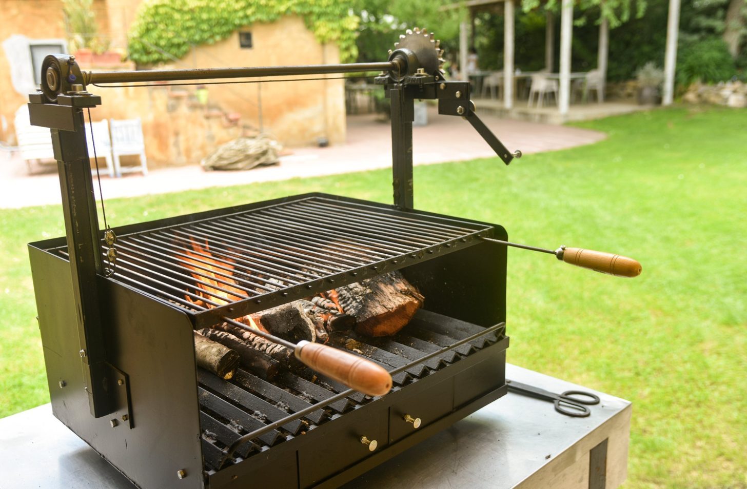 A wood-fired grill on the lawn, set up for an evening meal